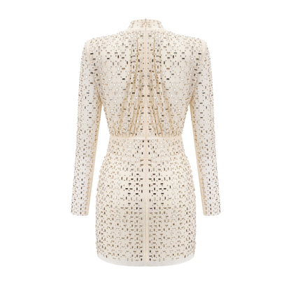 A short white mini dress with crystal embellishments and draped fabric detailing