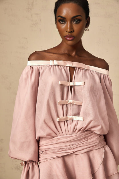 A pink offshoulder mini dress with a bow detail and ruffled hem