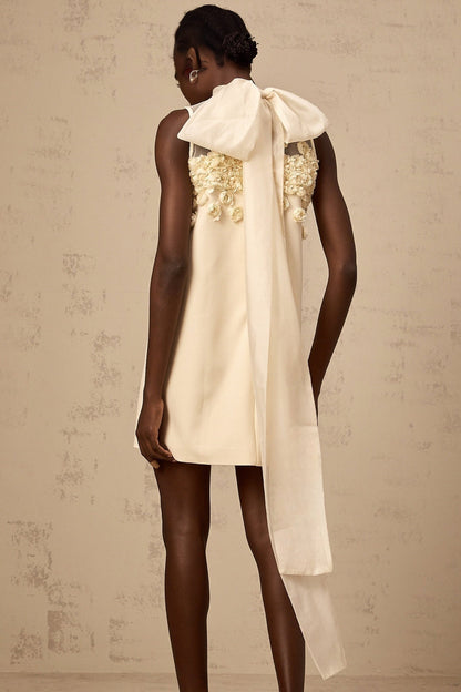 Young woman wearing a sleeveless mini dress with floral print pattern standing in front of white background