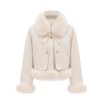 A white short coat made of suede with fur trim and padding worn by a model against a plain background