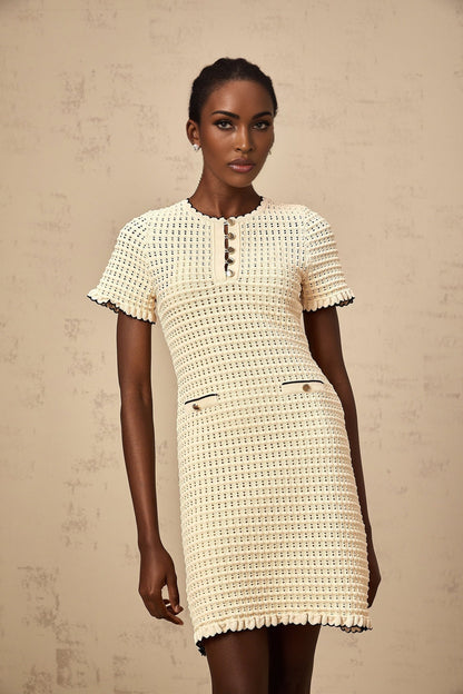 Beige knit mini dress with ruffled details and pointelle pattern featuring short sleeves and a fitted silhouette