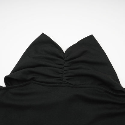Woman wearing a black longsleeved top with ruched detailing made from stretchy jersey fabric