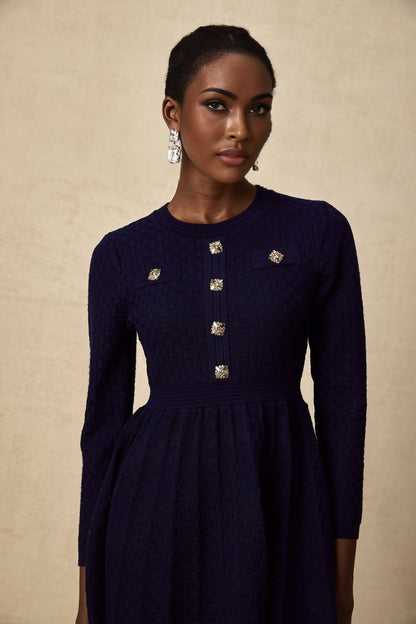 Woman wearing a navy blue mini dress with basket weave texture short sleeves and fitted silhouette